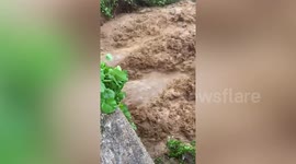Raging muddy river gushes under bridge after heavy rain in Burmese town