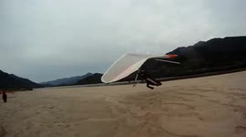 Hang glider landing fail - person ducks under glider