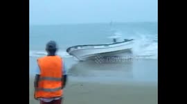 Boat runs into beach and flips over