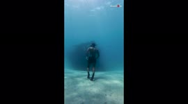 A man comes across a mysterious ship while walking in the depths of the ocean