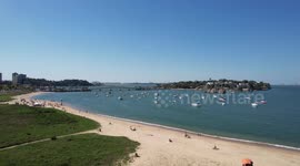 Beautiful flotilla of moored boats, close to the beach, with a view of the city.