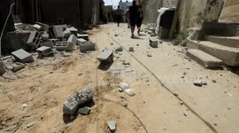 Palestinians inspect the ruins of a collapsed building destroyed by an Israeli air strike