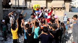 Palestinian children play on the rubble of houses which was destroyed by Israeli air strikes in the last conflict during a fun day