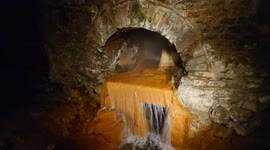Steaming hot water pours out of the ground at the thermal spring of Aquae Sulis, Bath, England in June 2022
