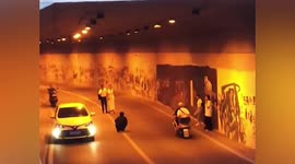 Vehicles drive past Chinese couple's photoshoot inside tunnel