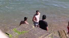 man hiving a full wash down  in sea meters away by Brighton pier