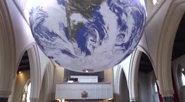 Visitors enjoy Luke Jerrams Gaia artwork celebrating planet Earth at All Saints Church Notting Hill