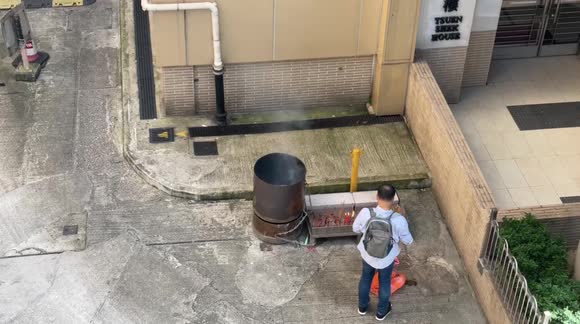 Man makes offerings to assuage spirits during “hungry ghosts month” in Hong Kong