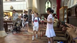 Young lady gets lifted up in the air as she takes pictures of Gaia installation at All Saints Church Notting Hill