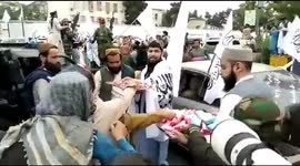 Armed Taliban distribute gifts to passing children to celebrate year anniversary of return to power in Afghanistan