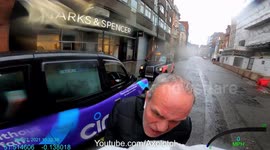 Road rage from a London taxi driver after he close passed within inches of cyclist, in the wet, with an oncoming vehicle. Police offered the driver a fixed penalty.