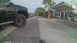 Unsafe cycling path. Car crosses into the path of a cyclist. Dangerous cycling infrastructure