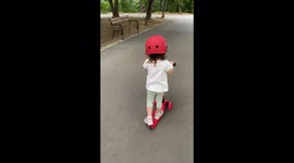 Girl on a scooter fearlessly speeding in the park