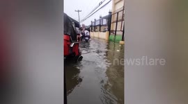 Parents carry students through floods as Tropical Storm Ma On batters the Philippines
