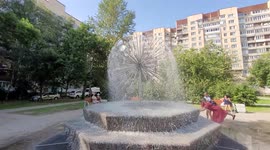 People are enjoying hot weather near the fountain that was built in an apartments local yard of St Petersburg,  Russia