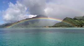 Spectacular rainbow stretches across turquoise water in French Polynesia.