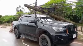 Heavy rain and strong wind blow electricity post onto car in Thailand