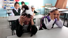 Palestinian schoolchildren cry as they remember classmate killed by Israeli airstrike on their first day back to school