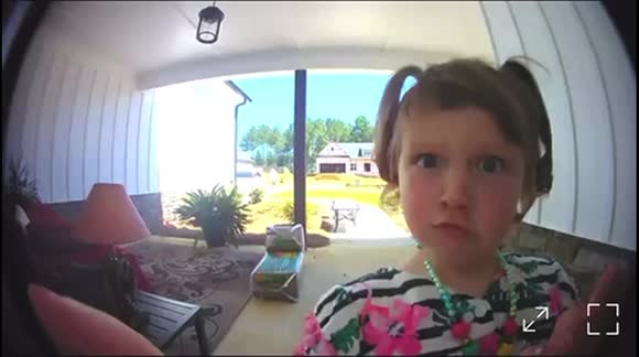 4 year old looking into the door camera while ringing bell