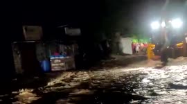 Locals rescued in a digger from raging floodwaters as heavy rain inundates western India