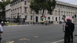 A pro Palestinian protestor cycles up and down outside Downing Street In London