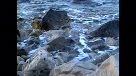 The waves of the sea break against the cliff