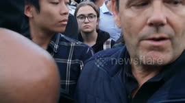 A unknown women takes charge of the flower laying outside Buckingham Palace as the police was so disorganised.