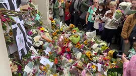 People lay flowers outside Buckingham Palace for the Queen