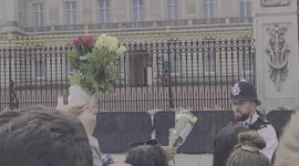 Policeman helps set flowers at Buckingham Palace for Queen Elizabeth ii commemorations