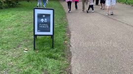 Queens floral tribute green park- people enter park to lay flowers
