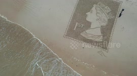 Sand artist creates incredible portrait of the Queen on a beach