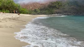 Forest burning on the crowded surfer beach in Lombok, Indonesia