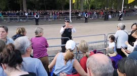 Police officer takes pictures for members of public waiting to see Queen's coffin