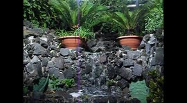 A small cascade of water descends from a wall made of volcanic stones from Vesuvius