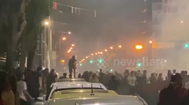 Droll moment a Greek protester does parkour over car rooftops to escape from police
