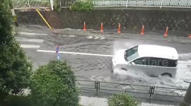 Cars struggle through Typhoon Nanmadol flood on roads in Tokyo, Japan