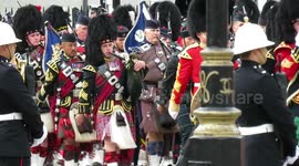 Down Whitehall near Downing Street the procession marches past looks like every top bod in the armed forces are here gun carriage pulled by the nave followed by King Charles and crew with family cars behind kate and kids queen consort  Megan markel on her