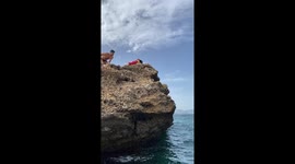 Dog, wearing a red cape, takes breathtaking flight over the sea and dives into it