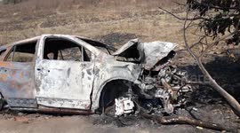A burnt out car on the road just outside in India ,  Burned out car in street outdoor