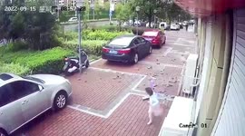 Tiles blown off building narrowly miss girl riding scooter below in China