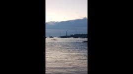 Marblehead Light Tower and a Large Sailboat Leaving Marblehead Harbor at Dawn