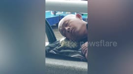 Chinese man uses TORTOISE as pillow while resting on embankment