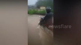 Rescuers help save motorcycle taxi drivers from overflowing river floods in Indonesia