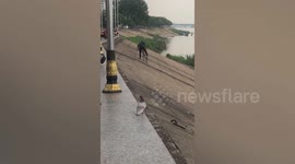 Stubborn cyclist falls over three times while trying to ride along embankment