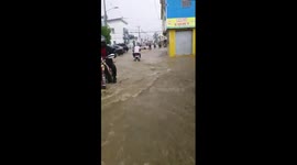 Motorcyclists struggle to pass through floodwater-stricken streets of Santiago, Chile