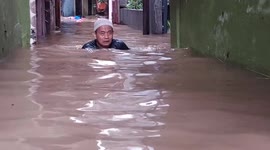 Residents walk through neck-deep water as floods hit East Jakarta, Indonesia