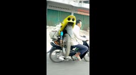 Motorcyclist carries motorbike on back while driving on roads