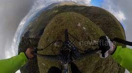 360 camera shows adrenaline junkie ride bike off a cliff in daring base jump stunt