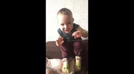 One year old sees himself in the Ipad and winks with his hands