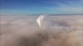 Factory chimney pokes through blanket of fog over Northern Irish town